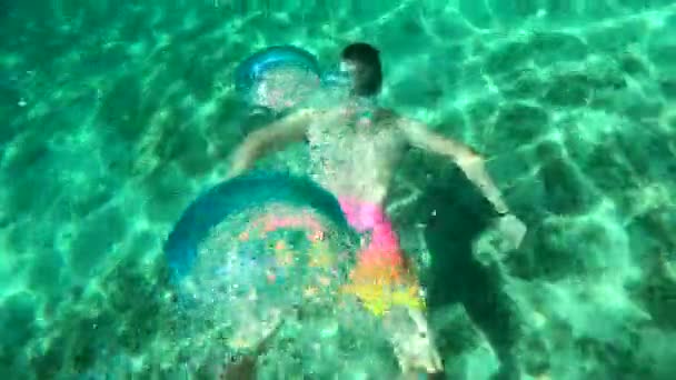 Young student fit male swimming underwater and having fun in summer — Stock Video