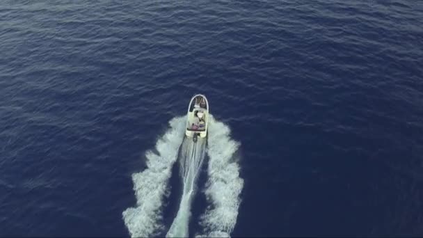 Aerial - Top down view of catching luxury motor boat racing on the water with family driving on it — Stock Video