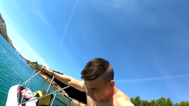 Jeune homme heureux sautant dans l'eau du bateau . — Video