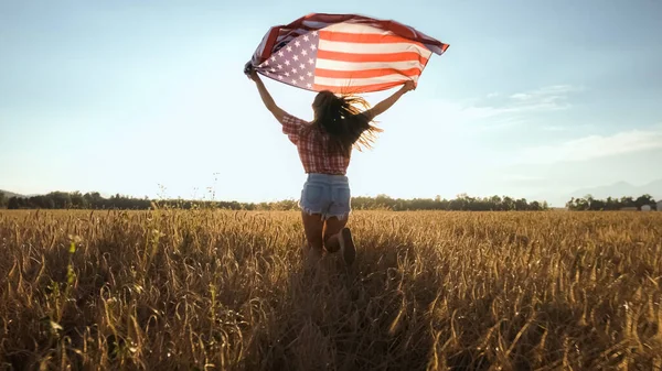 Mujer joven ondea una bandera americana — Foto de Stock