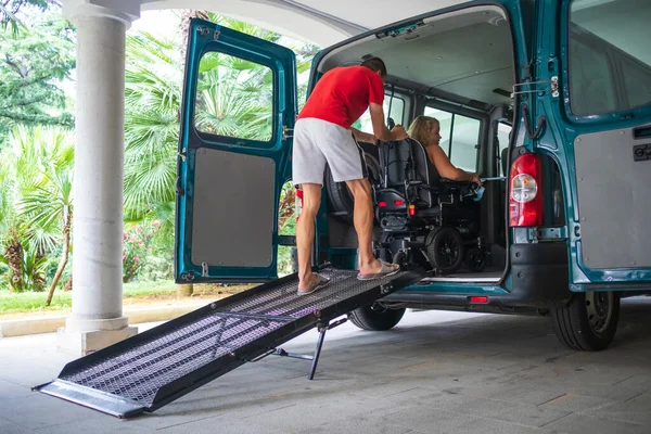 Disabled person on wheelchair using van ramp