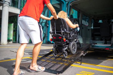 Minibüs rampası kullanarak tekerlekli sandalyedeki engelli kişi