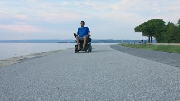 Человек на инвалидной коляске в море — стоковое видео