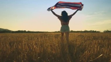 Genç bir kadın Amerikan bayrağı sallıyor.