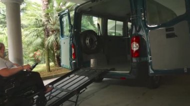 Minibüs rampası kullanarak tekerlekli sandalyedeki engelli kişi