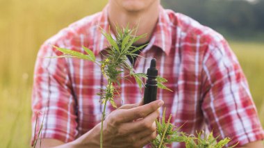 Cbd yağ şişesi tutan adam.
