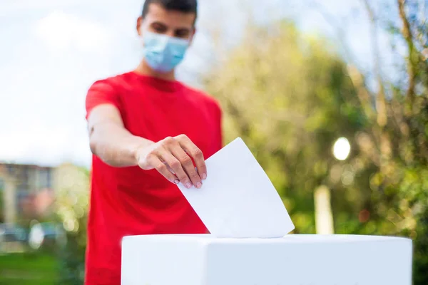 Hombre votando afuera con máscara facial —  Fotos de Stock