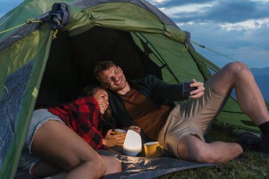 Sakin bir açık hava ortamında, çadırın içinde birkaç gevşeme, hafif bir ışık ve sıcak içeceklerle selfie çekerken kahkahalar atma..