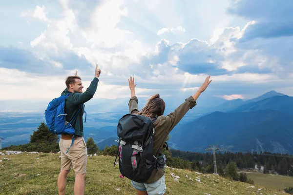 Güneş uzak tepelerin ardında batarken iki yürüyüşçü sevinçle kollarını kaldırarak güzelliklerini ve maceralarını sergiliyorlar..