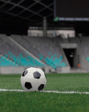 Futbol topu, geniş bir stadyumdaki yeşil sahada bir sonraki maça ya da antrenman oturumuna hazır..