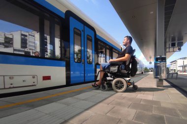 Tren istasyonunda engelli bir adam toplu taşıma araçlarıyla seyahat ediyor..