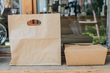 Kahverengi boş el çantası ve paket şablonu hazırlamak için sapı saplı, kıvrımlı karton kutu. Teslimat hizmeti konsepti. Boşluğu kopyala.
