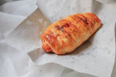 Kahvaltıda taze kabuklu ekmek ruloları. Hamur içinde ev yapımı sosisler susamlı ve yiyecek pazarında bademli kruvasanlar beyaz arka plan sergileniyor.