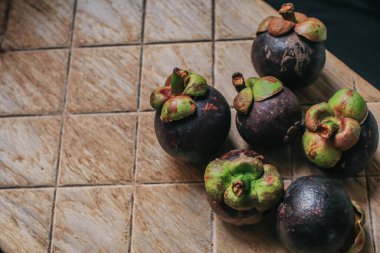 Lezzetli taze mangosteen ve enine kesit bir süpermarkette tropikal meyvelerin kraliçesinin kalın mor derisini ve beyaz etini gösteriyor..