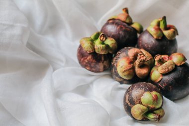 Lezzetli taze mangosteen ve enine kesit bir süpermarkette tropikal meyvelerin kraliçesinin kalın mor derisini ve beyaz etini gösteriyor..
