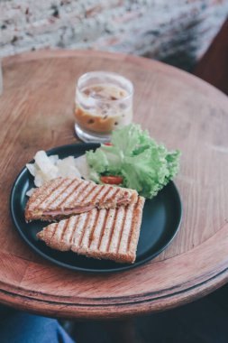 Lezzetli Sağlıklı Izgara Sandviç Peyniri ve salata (marul, jambon, peynir, domates ve patates cipsi) ve bir fincan kahve. Kahvaltı..