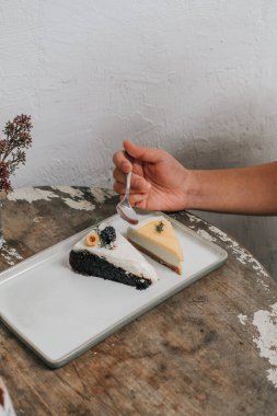 Kaşık kaşık ye Koyu bira çikolatalı pasta Dut ve limonlu kek beyaz tabakta servis edilir.