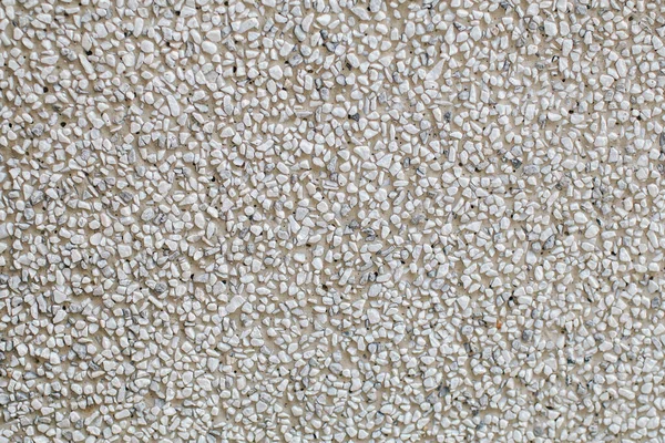 Close up Mini granite crushed stone wall texture background .Gray rubble construction rock pebble pattern.