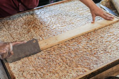 Geleneksel Tayland gevreği barı. Ev yapımı fıstıklı bisküviler, beyaz susam tohumları, çıtır pilav, hindistan cevizi sütü ve palmiye şekeri karıştırılmış ve ahşap kutuda parça parça kesilmiş..