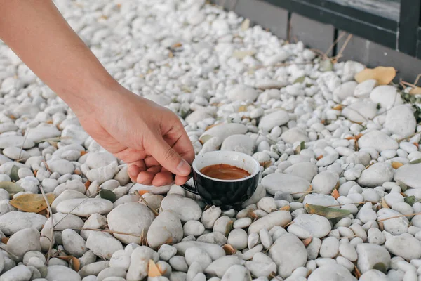 Tangan Mengambil Secangkir Kopi Hitam Panas Atas Batu Putih Lantai — Stok Foto