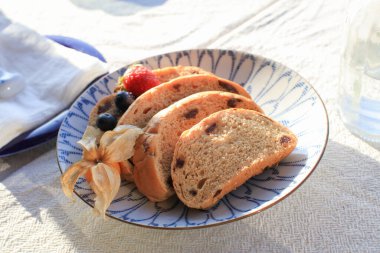 Sabah kahvaltısı için ev yapımı tahıllı ekmek. Güneş ışığı altında lüks beyaz tabakta..