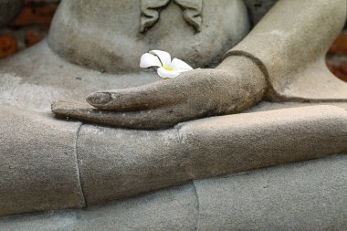 Zen, uyum ve sağlıklı yaşam kavramını gösteren lotus pozisyonunda bir Budist heykel elinin yakın çekim