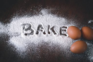 Yumurta ve unun kavramsal natürmort fotoğrafı, covid-19 salgınından dolayı ev karantinası sırasında zihinsel sağlığı desteklemek ve bununla başa çıkmak için bir yol olarak bir masanın üzerine döküldü.