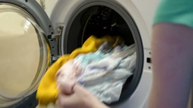 Kadın çamaşır makinesini temizliyor. Kadın çamaşır makinesi kullanıyor..