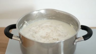 Yulaf ezmesi lapası tavada pişirir. Kahvaltıda lezzetli yulaf lapası pişirme.