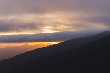 Yüksek dağlar ve geniş vahşi ormanlar arasında güzel günbatımı