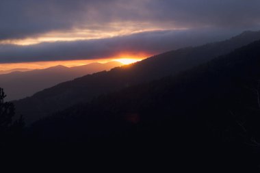 Yüksek dağlar ve geniş vahşi ormanlar arasında güzel günbatımı
