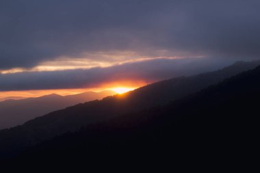 Yüksek dağlar ve geniş vahşi ormanlar arasında güzel günbatımı