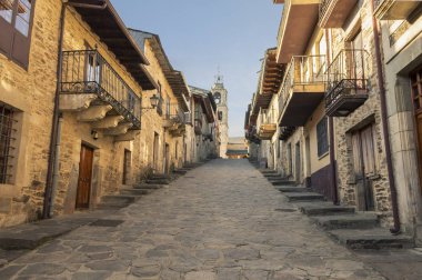 Nice medieval-style street of Puebla de Sanabria at sunset clipart