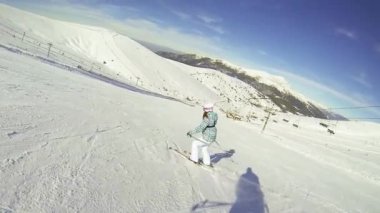 Güneşli bir günde kayak yapan genç bir kadın, Valdesqui 'nin ünlü Madrid istasyonunda kar barutuyla geniş bir pistte iniş egzersizi yapıyor. Ağır çekim, HD