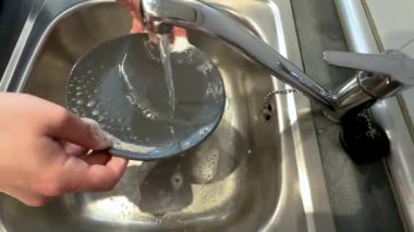 Kafkas erkek elleri mutfak lavabosunda sabun ve suyla tabağı duruluyor. Yaklaşın, konseptler, 4K