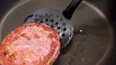 Yakından, peynirle doldurulmuş hamburger eti ve doğru yapılsın diye spatulayla çevrilmiş, 4k.