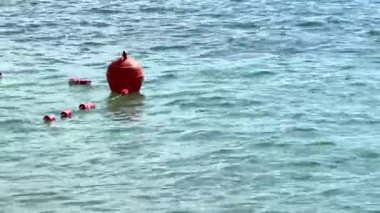 Mavi ve temiz okyanusta yüzen kırmızı şamandıra. Yüksek kalite