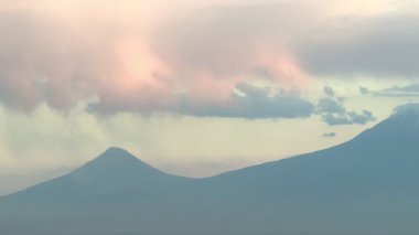 Bulut örtüsü ve günbatımında Türkiye 'nin Ararat Dağı etrafında uçan bir NATO savaş uçağı. Eylül 2025. Yüksek kalite 4k