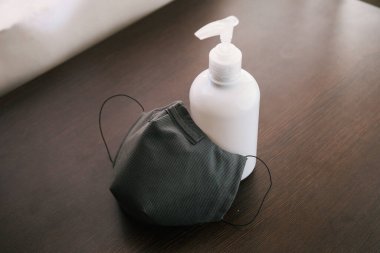 Temizleyici jel veya antibakteriyel sabun Coronavirus önleyici ölçü için bir termometre ve yüz maskesi, üst görünüm