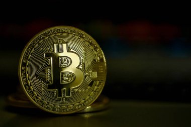 Koyu arka plan üzerinde parlak altın bitcoin 