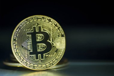 Koyu arka plan üzerinde parlak altın bitcoin 