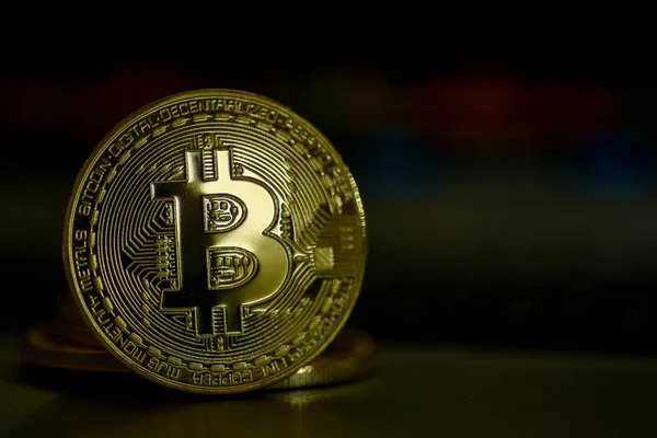 Koyu arka plan üzerinde parlak altın bitcoin 