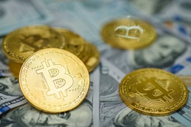 Birkaç yüz dolar faturaları arka plan üzerinde döşeme altın bitcoin paraları 