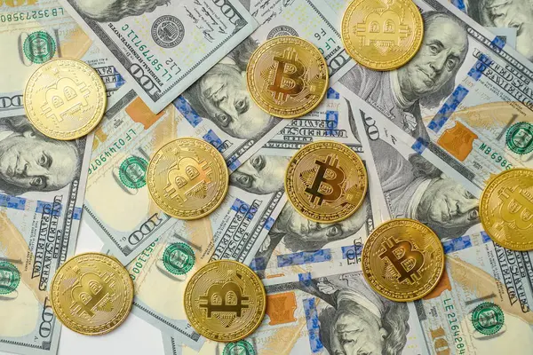 Birkaç yüz dolar faturaları arka plan üzerinde döşeme altın bitcoin paraları 