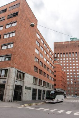 sokakta çok sayıda Windows ile kırmızı tuğla Sanayi Binaları ile otobüs gidiyor