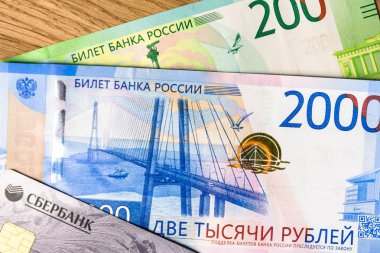 Odunsu bir arka plan üzerinde Para ve Sberbank kredi kartı