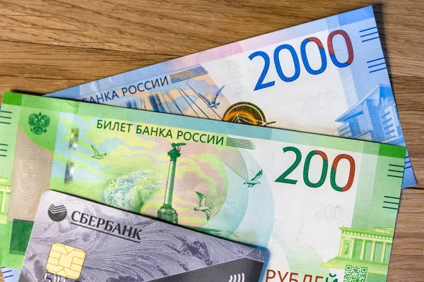 Деньги и кредитная карта Сбербанка на древесном фоне — стоковое фото