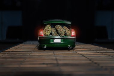 Farklı marihuana çeşitlerinin kuru tomurcukları küçük bir oyuncak arabanın bagajında. Detaylı çekim, bir sürü trikome ve thc.