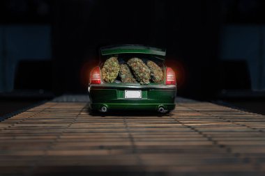 Dry buds of different varieties of marijuana, are in the trunk of a small toy car. Detailed shot, a lot of trichomes and thc. clipart
