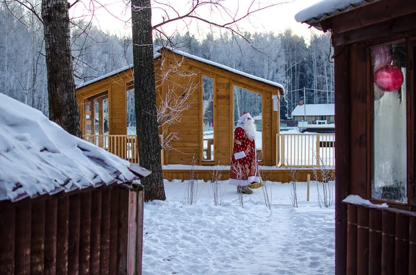 Vánoce, zima, prosinec. Santa Claus jde s pytlem dárků v zimě na zasněženém hřišti — Stock fotografie